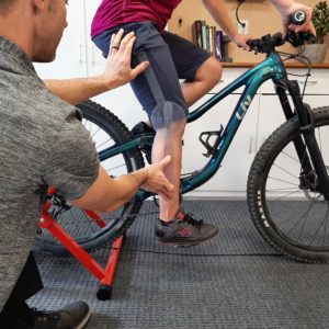 PT measuring knee range of motion for a mountain bike fit for a woman